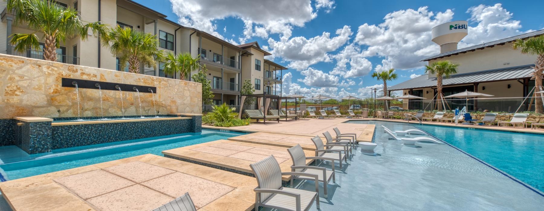 a pool with chairs and tables by it