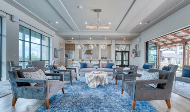 a room with a blue carpet and chairs and a chandelier